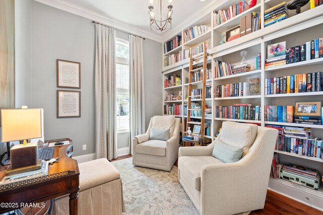 living area with crown molding, baseboards, wood finished floors, and an inviting chandelier