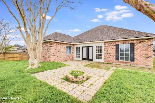 back of house with brick siding, a yard, a patio, a shingled roof, and fence