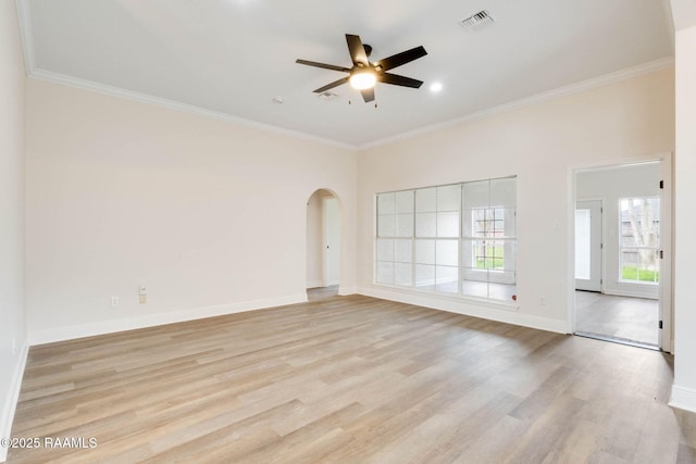 spare room featuring visible vents, arched walkways, baseboards, ornamental molding, and light wood-style floors