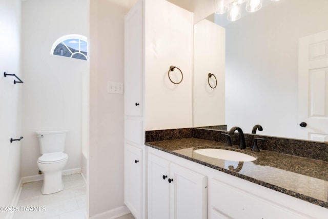 full bath with baseboards, vanity, toilet, and tile patterned floors