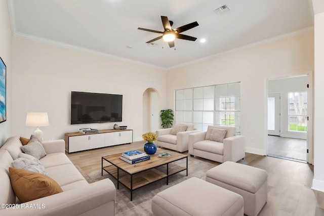 living area with visible vents, arched walkways, and crown molding