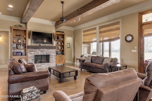 living area with light wood-style floors, a brick fireplace, beam ceiling, and plenty of natural light