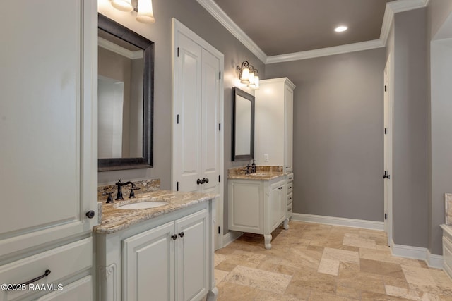 full bathroom with ornamental molding, two vanities, a sink, and baseboards