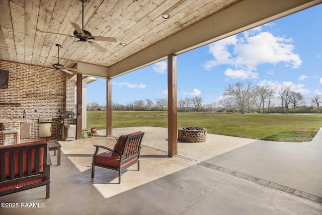 view of patio featuring a ceiling fan and an outdoor fire pit