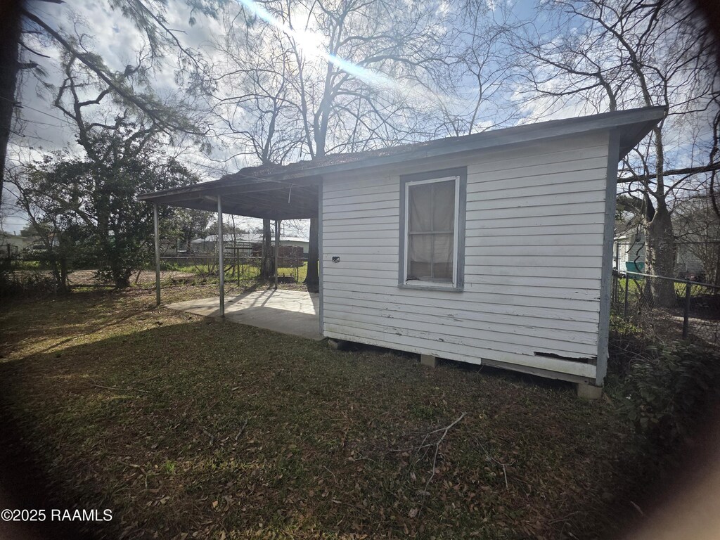638 Melancon St, Opelousas, LA 70570 - view of side of property with a patio, a carport, an outdoor structure, and fence