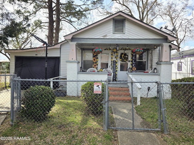 638 Melancon St, Opelousas, LA 70570 - view of front of home with a porch, a gate, brick siding, and a fenced front yard