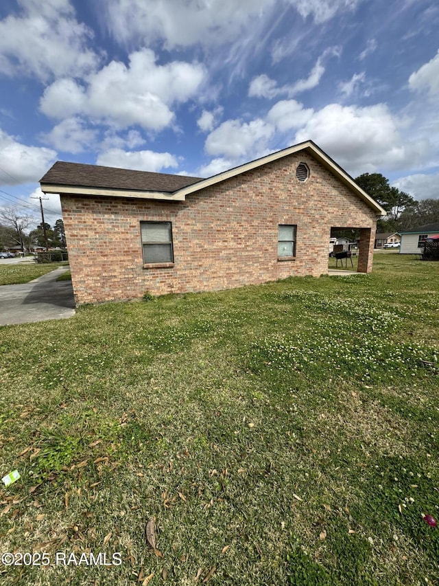 view of property exterior featuring a lawn and brick siding