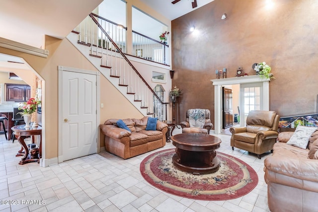 living room with a high ceiling, baseboards, stairs, and arched walkways