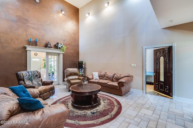 living room with a towering ceiling and baseboards