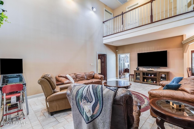 living area featuring baseboards and a high ceiling