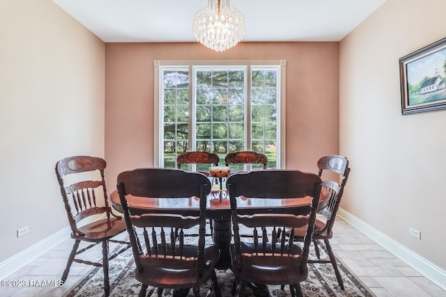 dining room featuring baseboards and an inviting chandelier