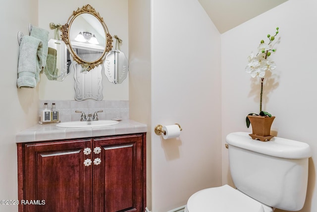 half bathroom featuring vanity and toilet