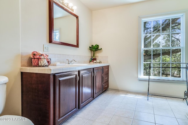 bathroom featuring toilet, tile patterned flooring, and vanity