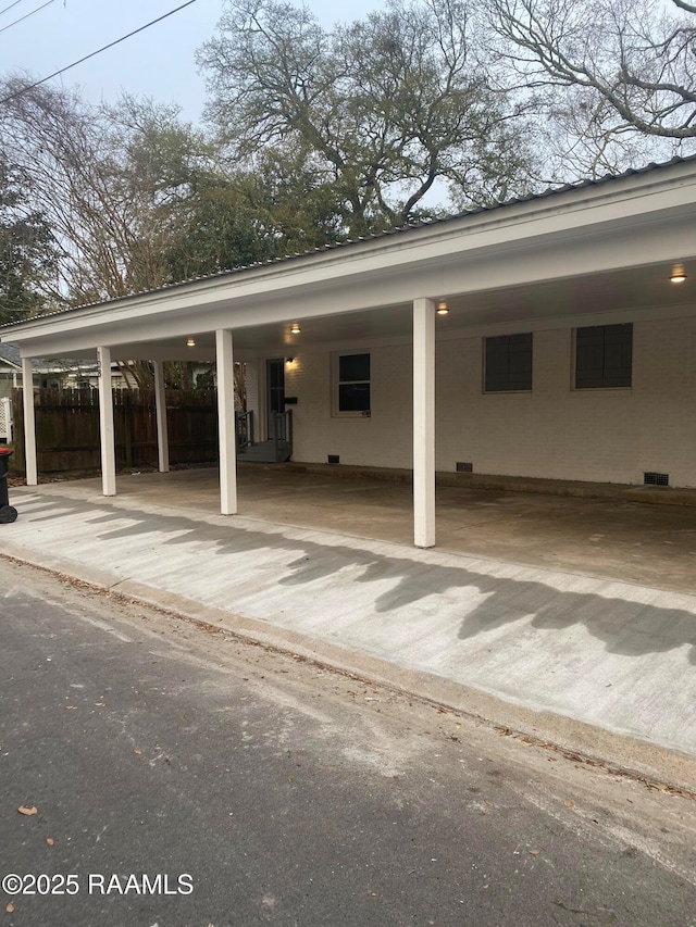 view of car parking with a carport and fence