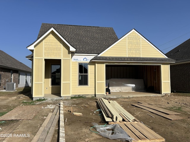 property in mid-construction featuring central air condition unit and roof with shingles