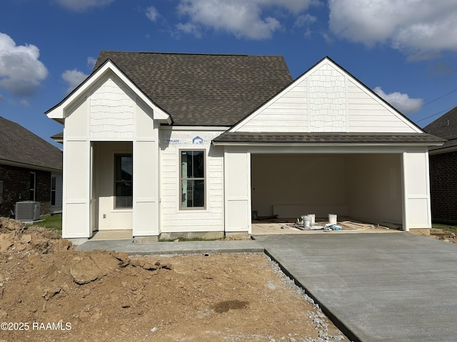 view of front facade featuring central AC, driveway, a shingled roof, and a garage