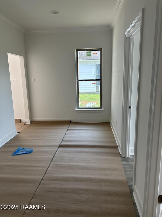 unfurnished bedroom featuring crown molding, baseboards, and wood finished floors