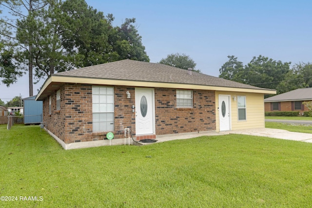 single story home featuring a front lawn, brick siding, and roof with shingles