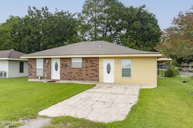 ranch-style home with brick siding, roof with shingles, and a front lawn