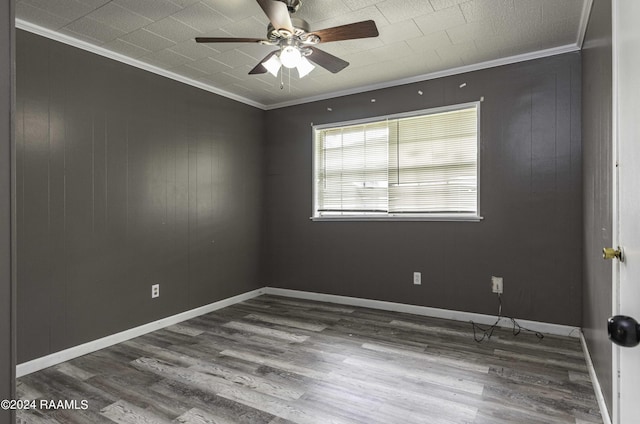 spare room with ceiling fan, wood finished floors, and ornamental molding