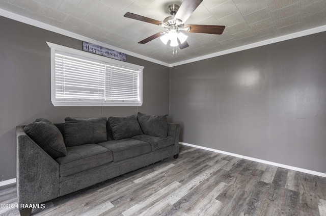 unfurnished living room featuring ceiling fan, wood finished floors, baseboards, and ornamental molding