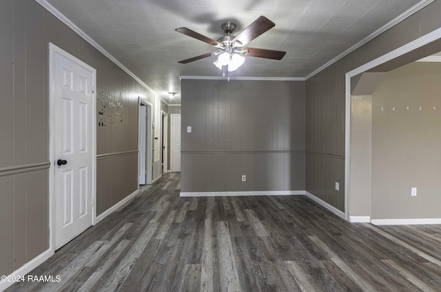 empty room featuring wood finished floors, baseboards, and ornamental molding