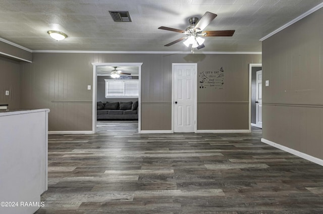 interior space featuring visible vents, ornamental molding, a ceiling fan, wood finished floors, and baseboards