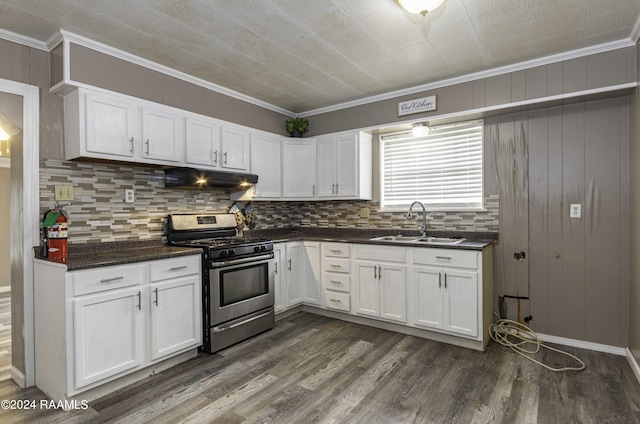 kitchen featuring under cabinet range hood, dark countertops, stainless steel range with gas cooktop, and a sink