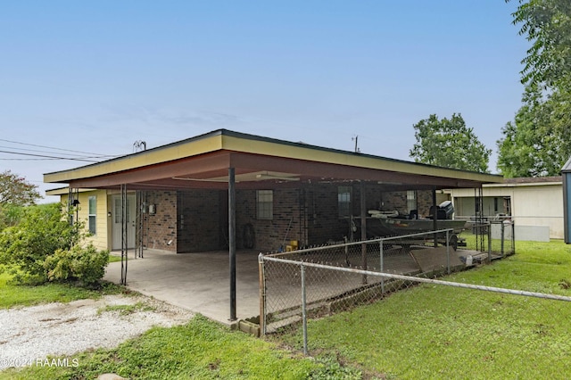 exterior space featuring a carport, a yard, fence, and brick siding