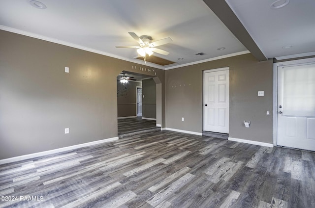 unfurnished room with baseboards, ornamental molding, wood finished floors, arched walkways, and a ceiling fan