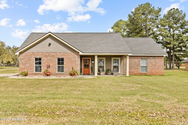 ranch-style house featuring a front yard, brick siding, and roof with shingles