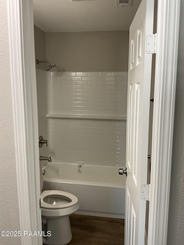 bathroom with tub / shower combination, visible vents, toilet, and wood finished floors