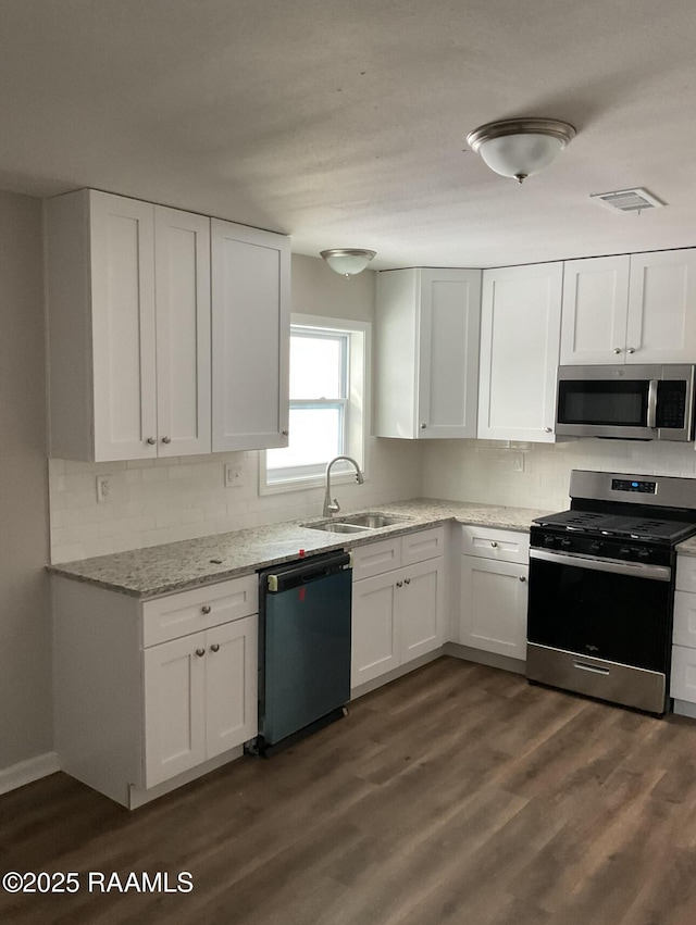 kitchen with stainless steel appliances, dark wood finished floors, visible vents, and a sink