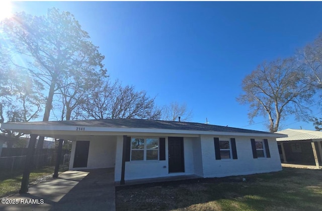 ranch-style house featuring a carport and driveway