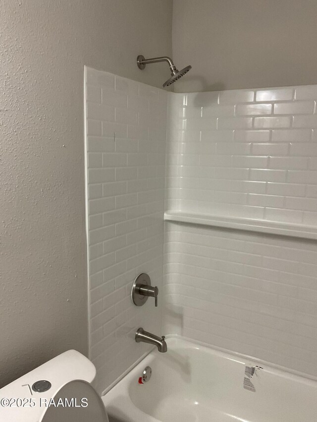 bathroom featuring a textured wall,  shower combination, and toilet