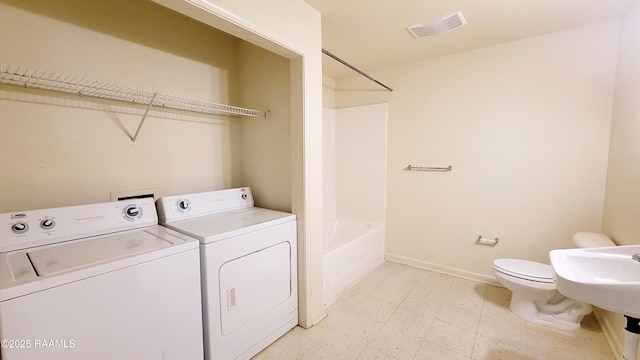 clothes washing area featuring laundry area, visible vents, baseboards, independent washer and dryer, and light floors