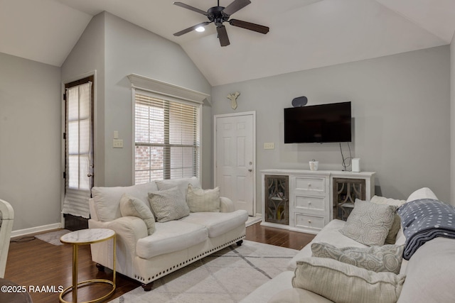 living area with dark wood finished floors, vaulted ceiling, a ceiling fan, and baseboards