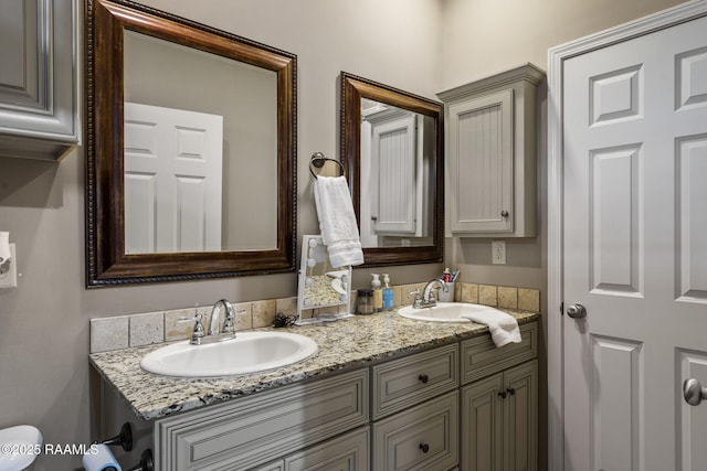 full bathroom with double vanity and a sink