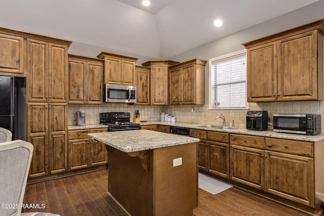 kitchen with tasteful backsplash, a sink, vaulted ceiling, black appliances, and dark wood-style flooring