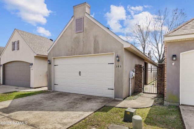 garage with concrete driveway and a gate