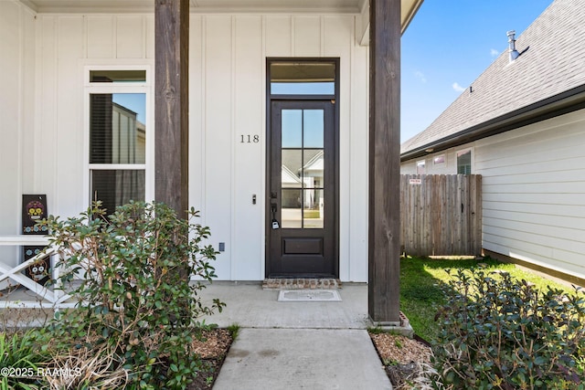 property entrance featuring board and batten siding and fence