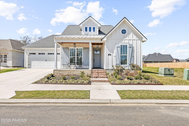 modern inspired farmhouse featuring driveway, board and batten siding, covered porch, an attached garage, and a shingled roof