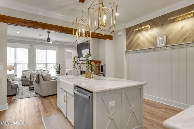 kitchen with light wood finished floors, an island with sink, crown molding, and stainless steel dishwasher