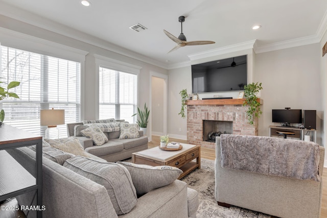 living room featuring visible vents, ornamental molding, and light wood finished floors