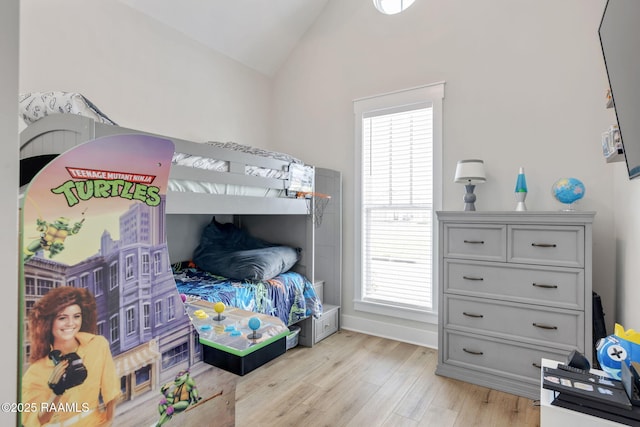 bedroom with lofted ceiling, multiple windows, light wood-style floors, and baseboards