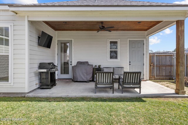 view of patio with area for grilling, a ceiling fan, and fence