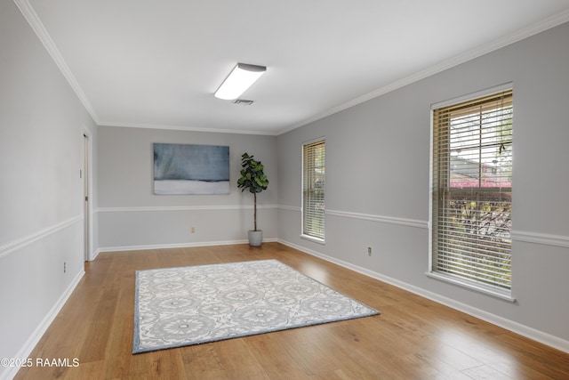 unfurnished room with visible vents, baseboards, and wood finished floors