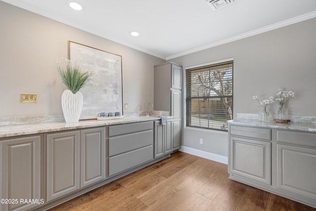 bathroom with visible vents, baseboards, ornamental molding, recessed lighting, and wood finished floors