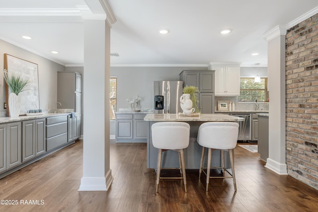 kitchen featuring a center island, gray cabinetry, stainless steel appliances, and dark wood-type flooring