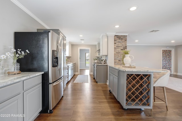 kitchen with visible vents, dark wood-type flooring, recessed lighting, appliances with stainless steel finishes, and a kitchen breakfast bar